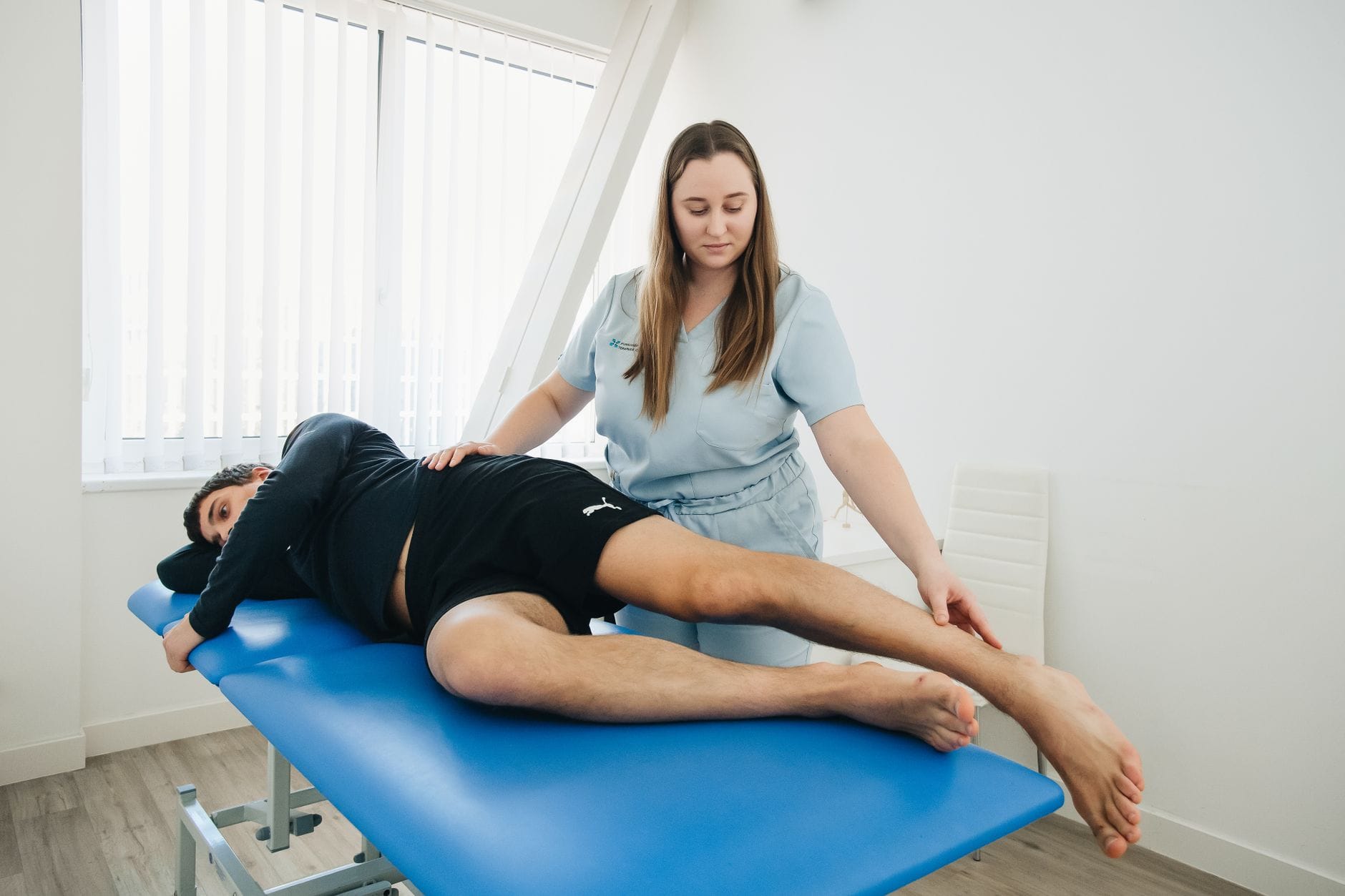 Planowanie ścieżki rozwoju fizjoterapeuty: od pracy w gabinecie do roli trenera medycznego i wykładowcy Fizjoterapeuta pomaga pacjentowi podczas ćwiczeń rehabilitacyjnych